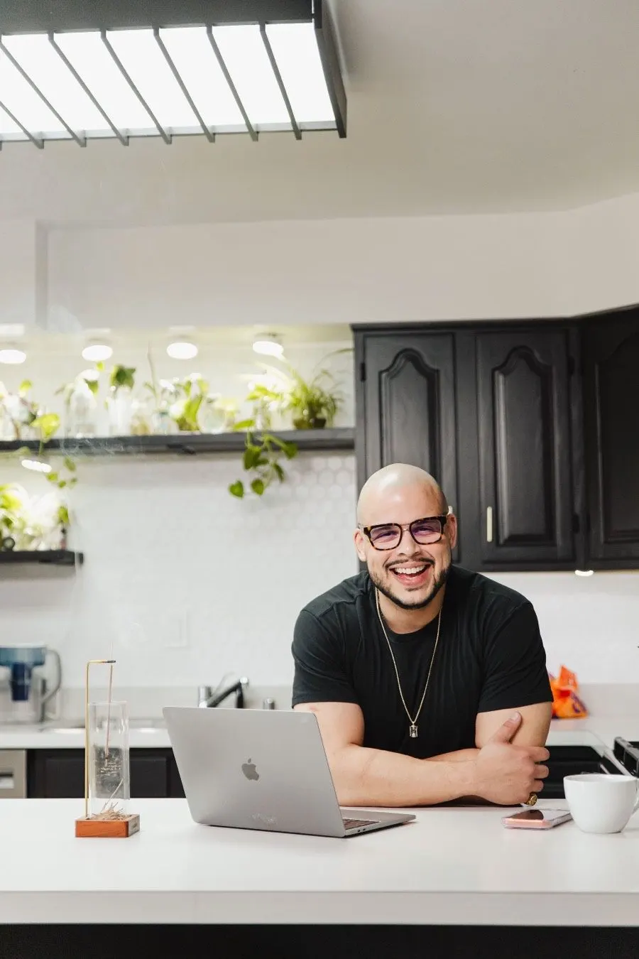 Willis Aybar of Another Monday in Baltimore, author of this Lovable SEO guide, smiling beside his laptop at a kitchen counter