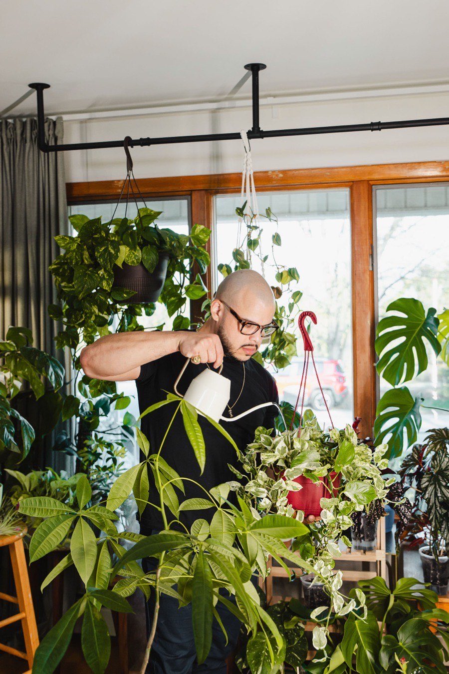 Willis Aybar of Another Monday watering plants at home in Baltimore, MD, between client work