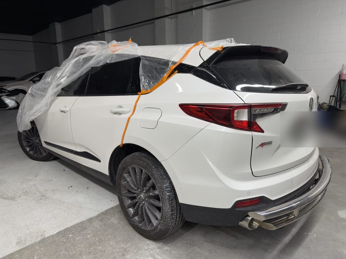 The same white Acura RDX repaired, repainted and masked for finishing at Exclusive Collision and Repair in Brooklyn, New York