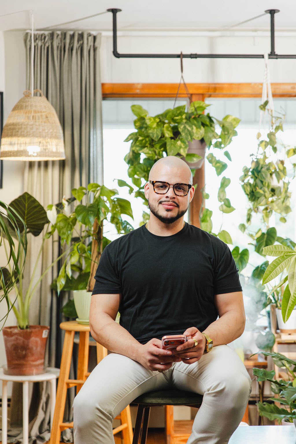 Willis Aybar, the small business marketing consultant behind Another Monday in Baltimore, MD, sitting with his phone in the studio where he takes client calls