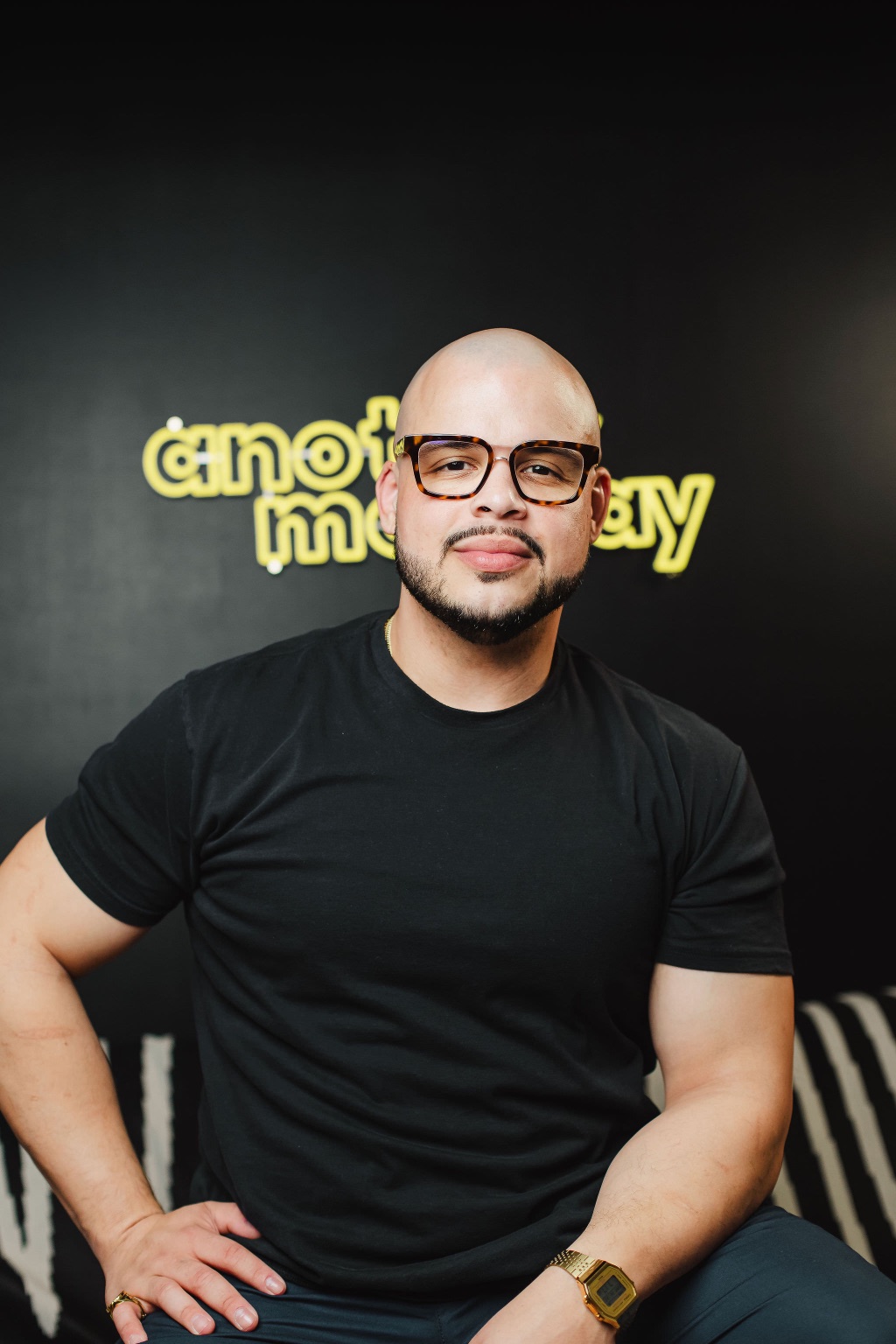 Willis Aybar in front of the Another Monday neon sign at the studio in Baltimore, MD
